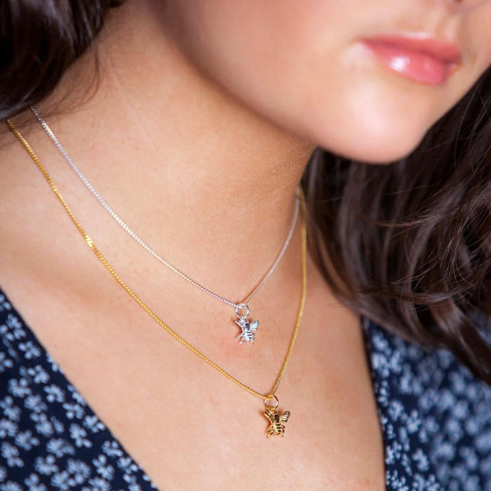 closeup of model wearing bee locket in gold