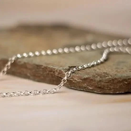 white gold belcher chain necklace resting on natural stone surface, close-up detail of round links