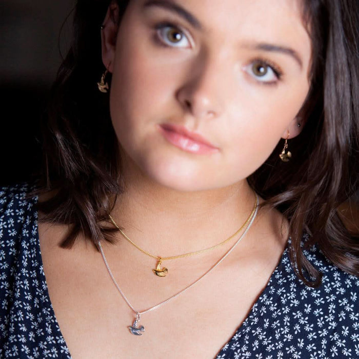 model wearing bird pendant in silver