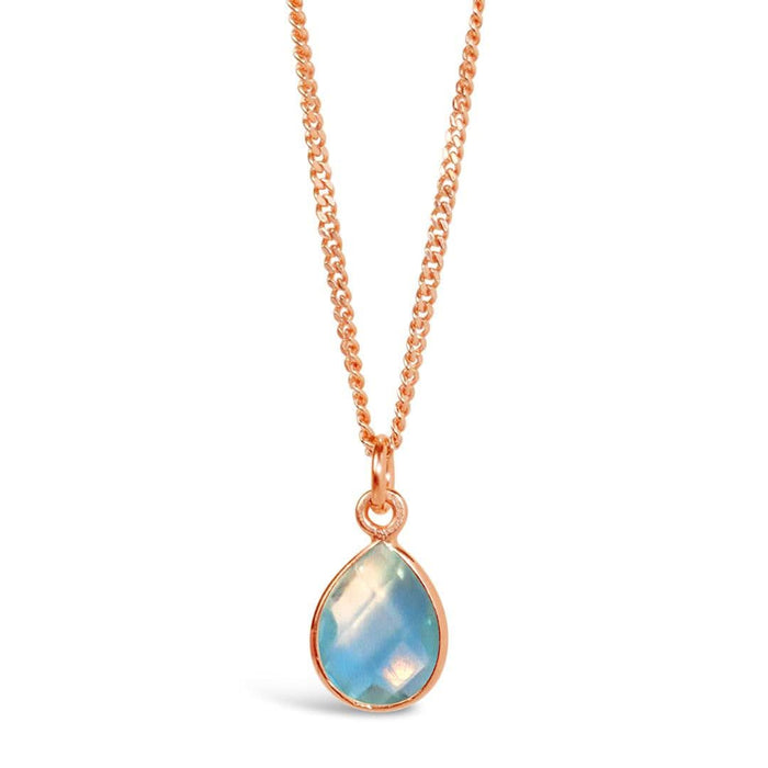 blue topaz charm necklace in rose gold on a white background