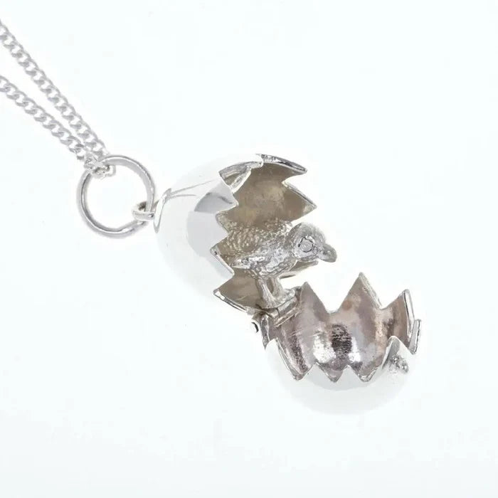 Detailed view of silver hatching chick locket pendant with hinged opening egg and textured chick interior