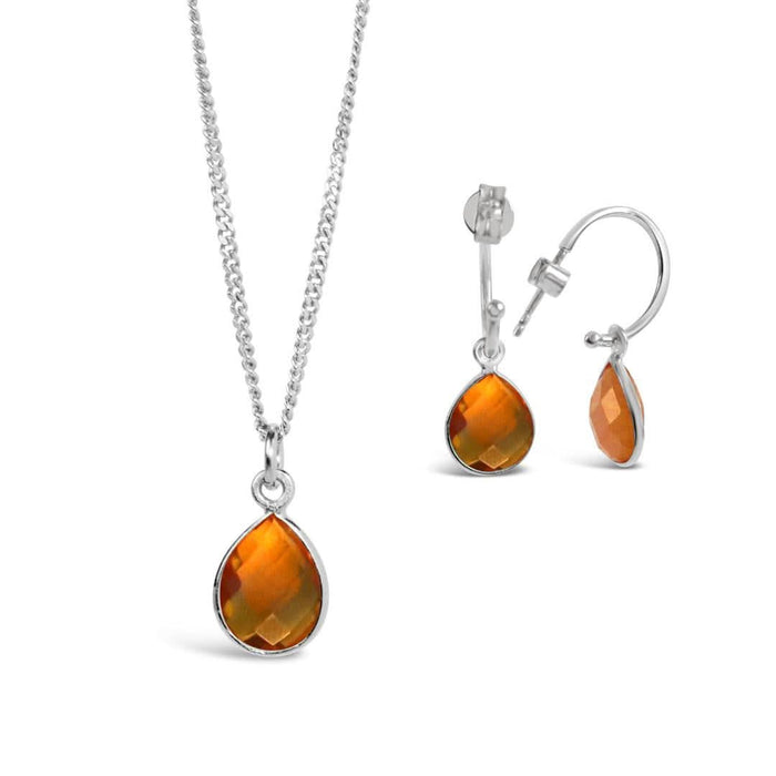 citrine drop hoop earrings in silver and charm necklace on a white background