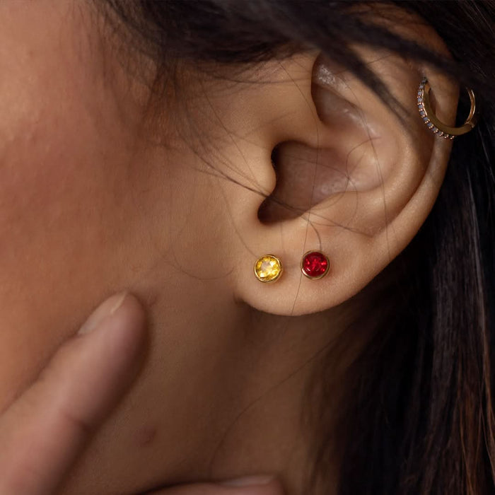 Up close model image wearing citrine mini stud earrings in gold