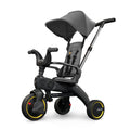 A compact grey Doona Liki Trike S1 with yellow accents, featuring a multi-position reclining backrest, parent control bar, footrest, armrest, and canopy.