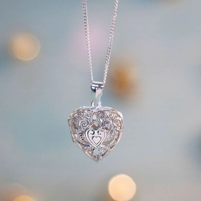 Filigree heart locket in silver on a blue background