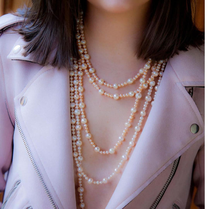 model wearing eternal pearl necklace in champagne