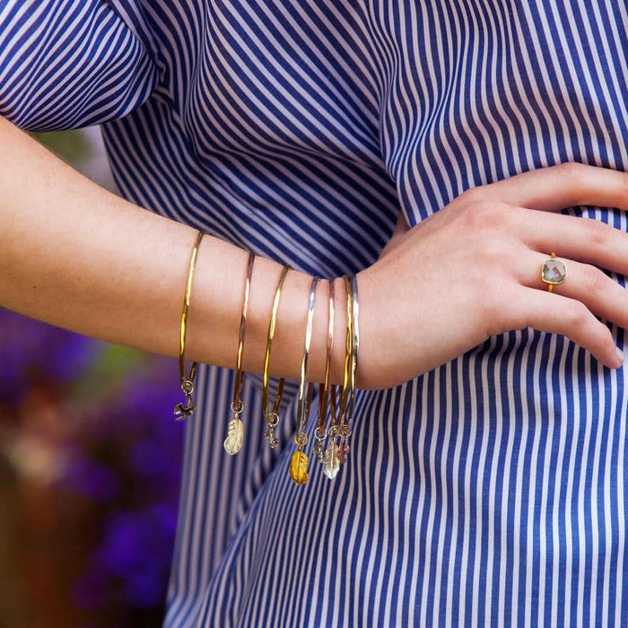 model wearing multiple feather bangles