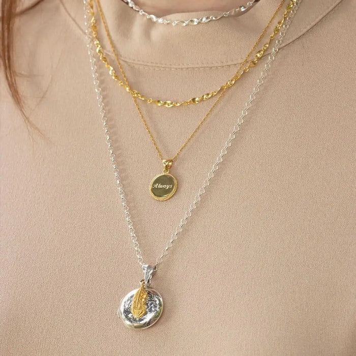 Layered sterling silver and gold necklaces with feather locket pendant, personalised keepsake jewellery styling