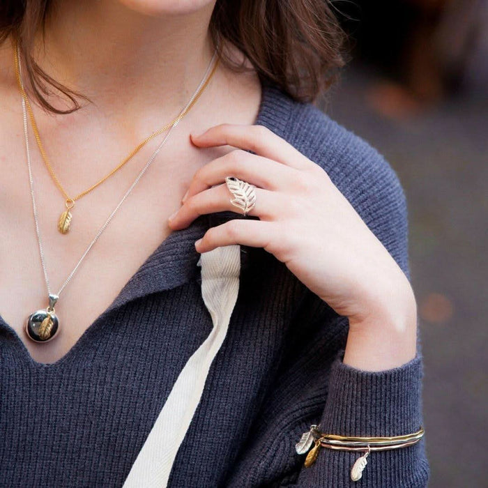 model wearing feather pendant in gold