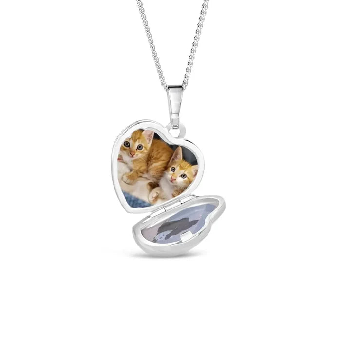 Sterling silver heart locket necklace opened to reveal two personalised photos inside, suspended on a delicate silver chain against a clean white background.