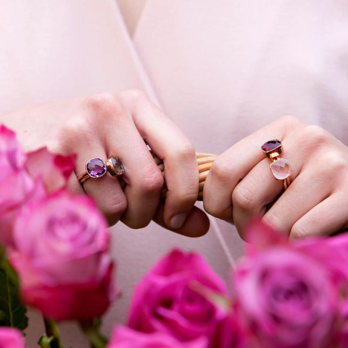 model wearing four cocktail rings in rose gold  each with different gemstones
