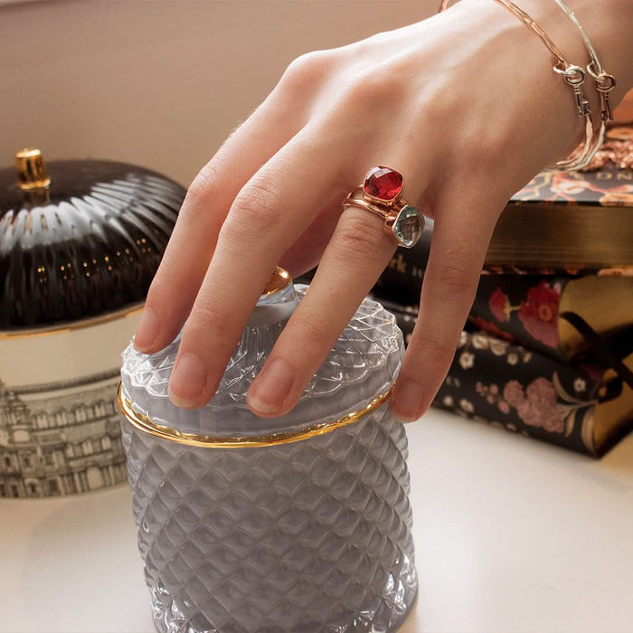 close up of model wearing two cocktail rings with different gemstones