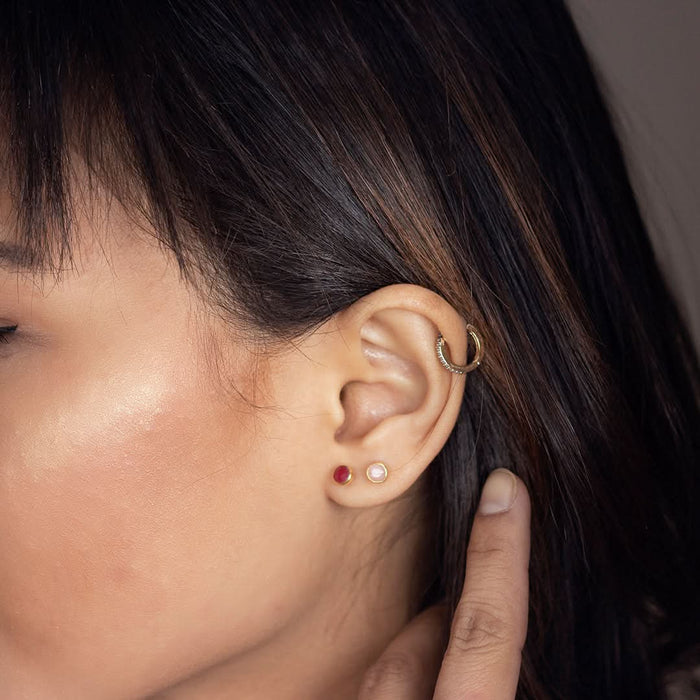 model is wearing garnet mini stud earrings in silver