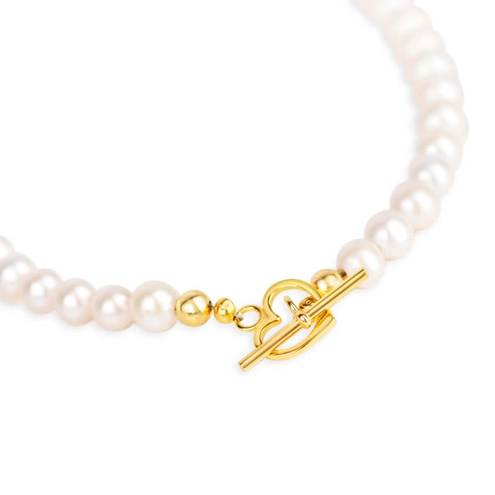 heart shaped gold catch on white pearl necklace with gold filigree heart locket
