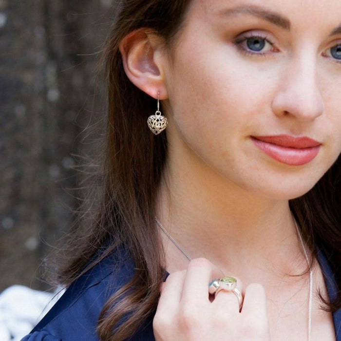 model wearing heart earrings in silver
