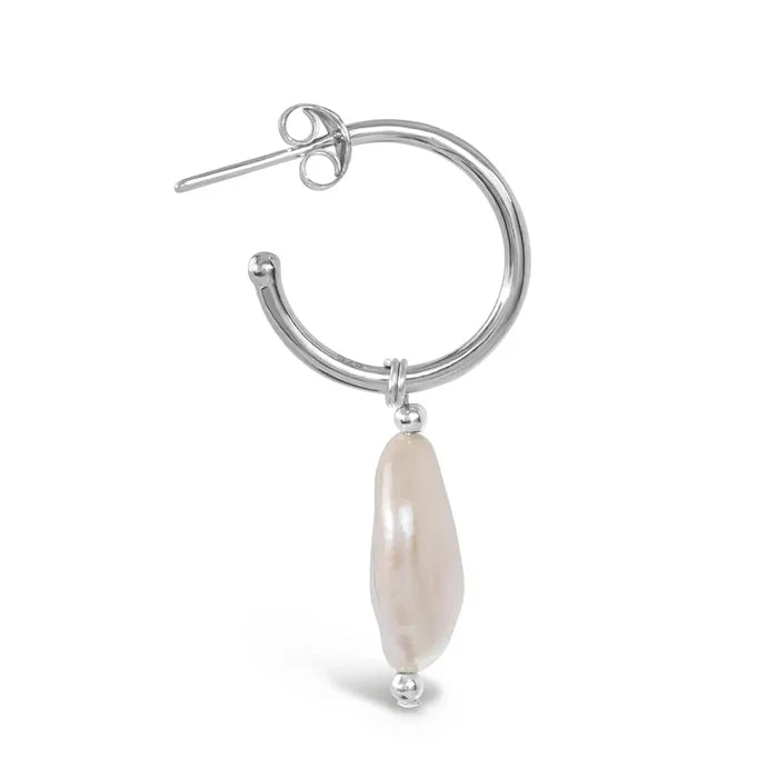 Close-up side view of silver hoop earring with elongated coin pearl drop detail