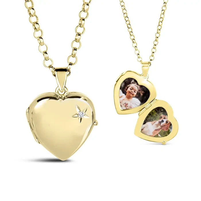 Gold heart-shaped locket necklace by Lily Blanche, with a diamond accent on the front. The locket is shown both closed and open — inside are two heart-shaped photo spaces displaying a picture of a smiling child and a dog.