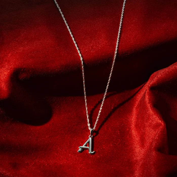 Sterling silver initial A pendant necklace on fine chain, polished finish on red satin background