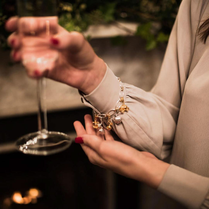 model wearing bracelet with five magical charms attached