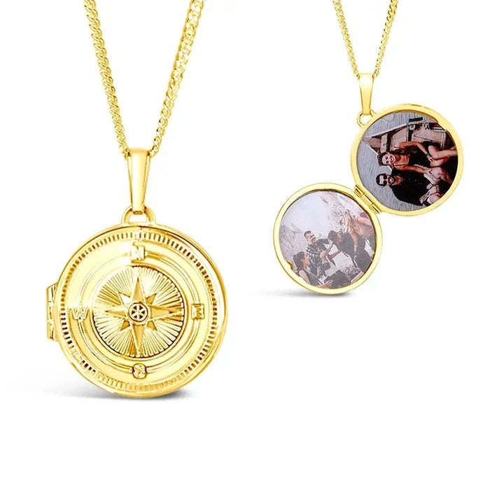 Gold compass locket necklace with engraved front and open interior showing space for two photos, white background