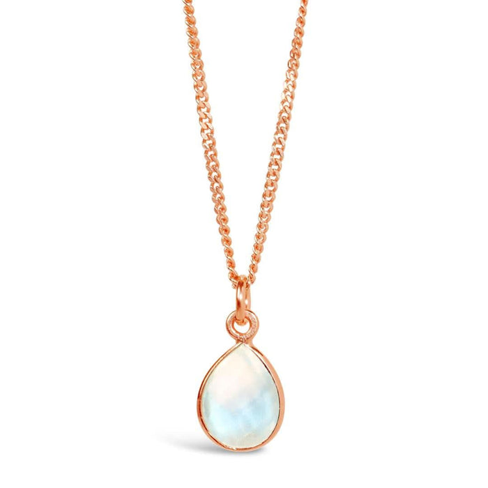 A natural moonstone charm necklace in a rose gold setting, hanging from a rose gold curb chain, photographed on a white background.