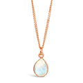 A natural moonstone charm necklace in a rose gold setting, hanging from a rose gold curb chain, photographed on a white background.