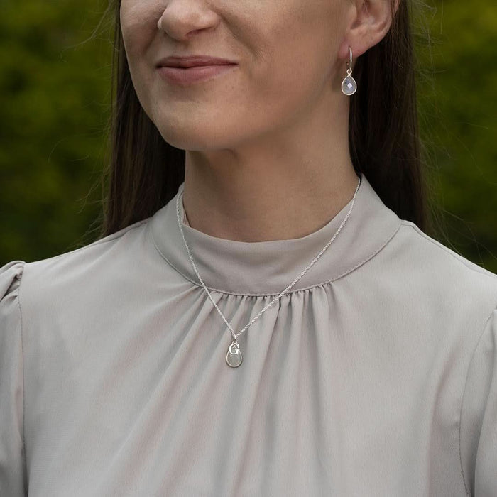 model wearing moonstone drop hoop earrings in silver