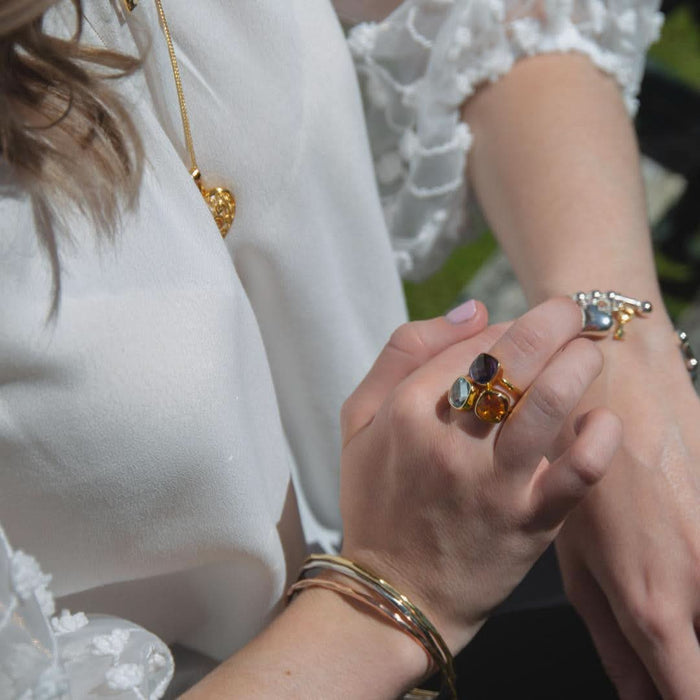 model wearing stack of cocktail rings in rose gold