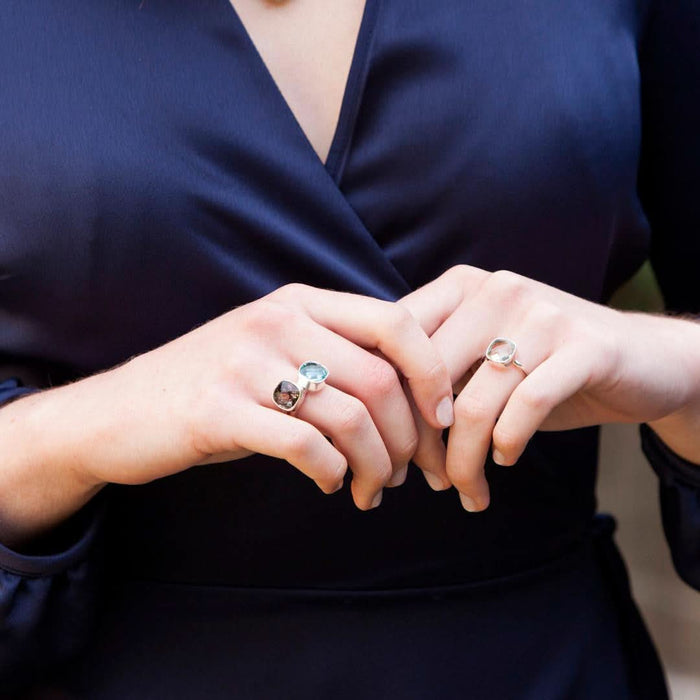 model wearing three cocktail rings in silver with different gemstones