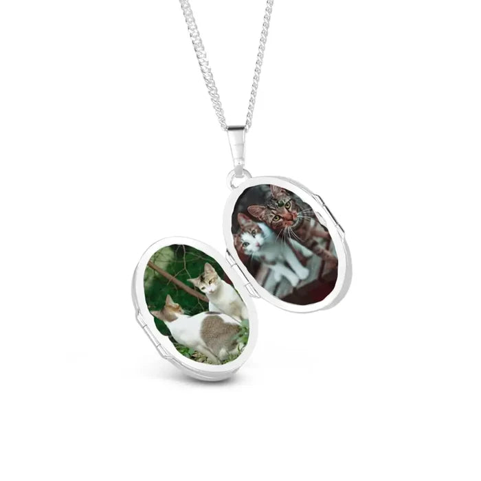 Open sterling silver oval photo locket necklace on chain, displaying two personalised pet photos inside, polished finish against a light grey background.